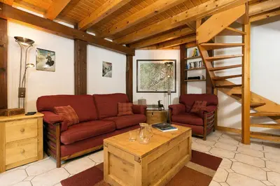 a living room with a couch and a staircase at Apartment Vila 1 - Cosy Central Chamonix Loft in Chamonix-Mont-Blanc