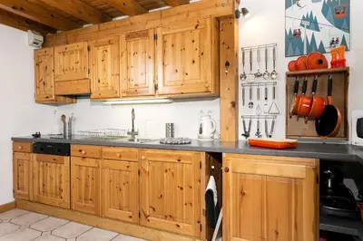 a kitchen with wooden cabinets and a black counter top at Apartment Vila 1 - Cosy Central Chamonix Loft in Chamonix-Mont-Blanc