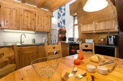a kitchen with wooden cabinets and a wooden table at Apartment Vila 1 - Cosy Central Chamonix Loft in Chamonix-Mont-Blanc