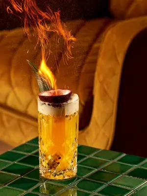 a drink on a table with a fire in it at Hôtel L'Arboisie in Megève