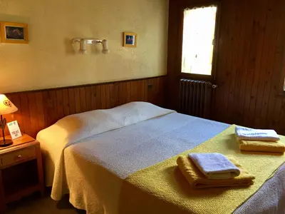 a bedroom with two beds with towels on a table at La Gelinotte in Les Contamines-Montjoie