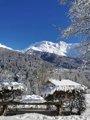 a snow covered mountain with a house and a fence at La Gelinotte in Les Contamines-Montjoie