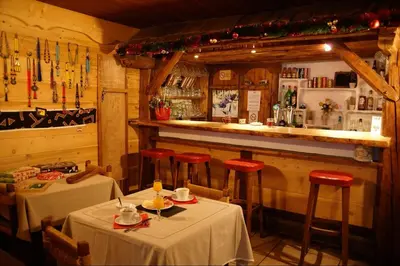 a restaurant with two tables and a bar at La Gelinotte in Les Contamines-Montjoie