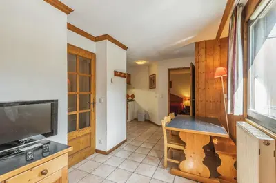 a living room with a television and a table at maeva Home Résidence la Rivière in Chamonix-Mont-Blanc