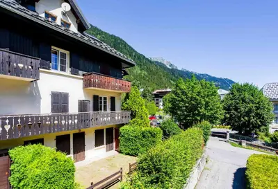a building with a balcony next to a street at La Saleina Apartment - Chamonix All Year in Chamonix-Mont-Blanc
