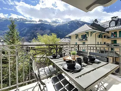 a table on a balcony with a view of mountains at Appartement T3 au Centre de Chamonix avec WIFI et Parking - FR-1-507-3 in Chamonix-Mont-Blanc