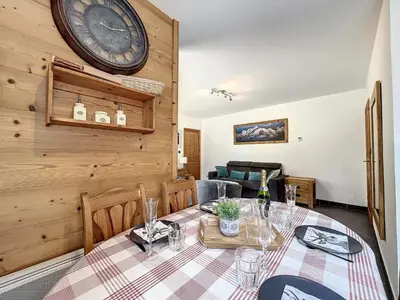 a dining room with a table and a clock on the wall at Appartement T3 au Centre de Chamonix avec WIFI et Parking - FR-1-507-3 in Chamonix-Mont-Blanc