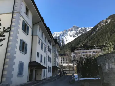 a street in a town with mountains in the background at Chamonix centre, 64m², 6 pers., 2 chambres, parking - FR-1-507-14 in Chamonix-Mont-Blanc