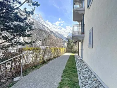 a path between two buildings with a snow covered mountain at Chamonix centre, 64m², 6 pers., 2 chambres, parking - FR-1-507-14 in Chamonix-Mont-Blanc