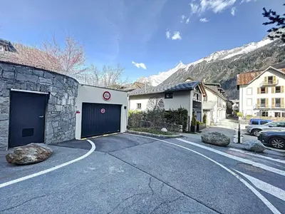 a parking lot in front of a building with a garage at Chamonix centre, 64m², 6 pers., 2 chambres, parking - FR-1-507-14 in Chamonix-Mont-Blanc