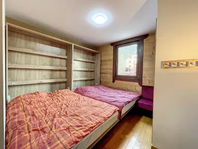 a bedroom with a bed in a room with wooden walls at Chamonix centre, 64m², 6 pers., 2 chambres, parking - FR-1-507-14 in Chamonix-Mont-Blanc