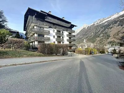 a large building on the side of a road at Appartement Chaleureux à Chamonix, 4 Pers, Près du Brévent avec Terrasse et Parking - FR-1-507-26 in Chamonix-Mont-Blanc