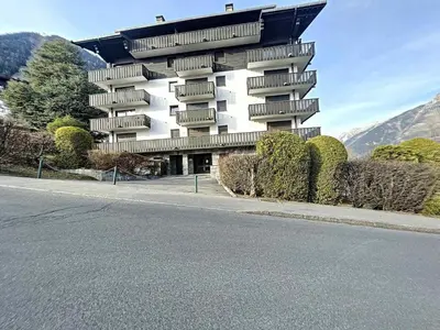 a large building on the side of a road at Appartement Chaleureux à Chamonix, 4 Pers, Près du Brévent avec Terrasse et Parking - FR-1-507-26 in Chamonix-Mont-Blanc