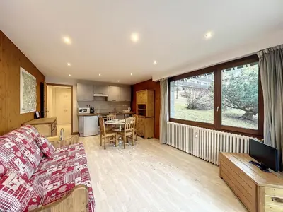 a living room with a couch and a kitchen at Appartement Chaleureux à Chamonix, 4 Pers, Près du Brévent avec Terrasse et Parking - FR-1-507-26 in Chamonix-Mont-Blanc