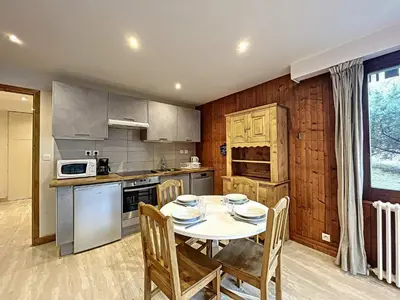 a kitchen with a table and chairs and a table and a kitchen with a table at Appartement Chaleureux à Chamonix, 4 Pers, Près du Brévent avec Terrasse et Parking - FR-1-507-26 in Chamonix-Mont-Blanc