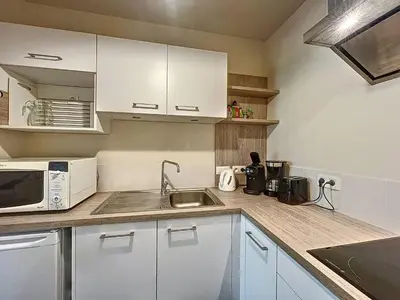 a kitchen with white cabinets and a sink and a microwave at T2 spacieux 45m² pour 4 pers, centre Chamonix, parking inclus - FR-1-507-27 in Chamonix-Mont-Blanc