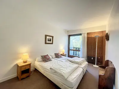 a bedroom with a bed and a large window at T2 spacieux 45m² pour 4 pers, centre Chamonix, parking inclus - FR-1-507-27 in Chamonix-Mont-Blanc