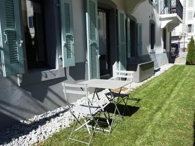 two chairs and a table on the side of a house at Appartement cosy au centre de Chamonix avec jardin, 2 pièces, bien équipé, accepte animaux - FR-1-507-29 in Chamonix-Mont-Blanc