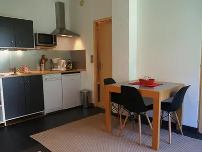 a kitchen with a table and chairs in a room at Appartement cosy au centre de Chamonix avec jardin, 2 pièces, bien équipé, accepte animaux - FR-1-507-29 in Chamonix-Mont-Blanc