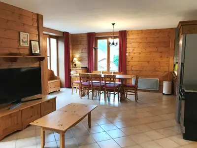 a living room with a table and chairs and a television at Appartement de standing Chamonix 4 pers, parking/ski - FR-1-507-34 in Chamonix-Mont-Blanc