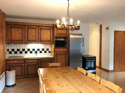 a kitchen with a wooden table and a refrigerator at Appartement de standing Chamonix 4 pers, parking/ski - FR-1-507-34 in Chamonix-Mont-Blanc