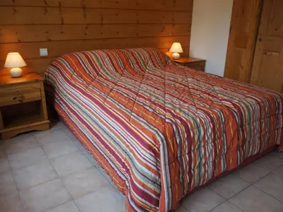 a bed with a colorful blanket on it in a room at Appartement de standing Chamonix 4 pers, parking/ski - FR-1-507-34 in Chamonix-Mont-Blanc