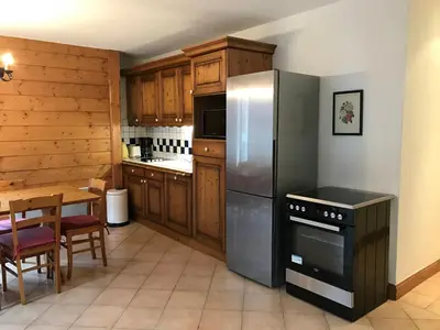a kitchen with a stainless steel refrigerator and a table at Appartement de standing Chamonix 4 pers, parking/ski - FR-1-507-34 in Chamonix-Mont-Blanc