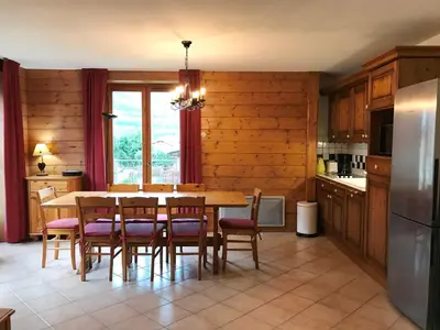 a kitchen with a table and chairs and a refrigerator at Appartement de standing Chamonix 4 pers, parking/ski - FR-1-507-34 in Chamonix-Mont-Blanc