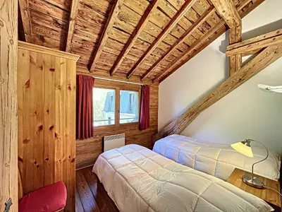 a bedroom with two beds in a room with wooden ceilings at Chamonix: Appart. standing 6 pers, 3 ch, parking, centre-ville - FR-1-507-35 in Chamonix-Mont-Blanc