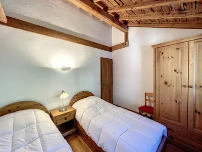two beds in a room with wooden ceilings at Chamonix: Appart. standing 6 pers, 3 ch, parking, centre-ville - FR-1-507-35 in Chamonix-Mont-Blanc