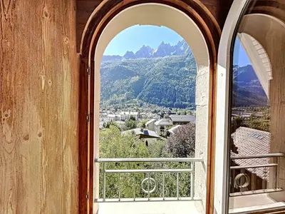 an open window with a view of a mountain at Chamonix: Appart. standing 6 pers, 3 ch, parking, centre-ville - FR-1-507-35 in Chamonix-Mont-Blanc