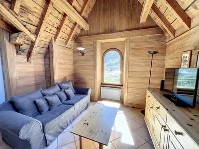 a living room with a blue couch and a tv at Chamonix: Appart. standing 6 pers, 3 ch, parking, centre-ville - FR-1-507-35 in Chamonix-Mont-Blanc