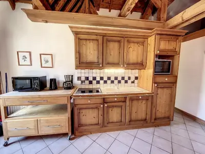 a kitchen with wooden cabinets and a microwave at Chamonix: Appart. standing 6 pers, 3 ch, parking, centre-ville - FR-1-507-35 in Chamonix-Mont-Blanc