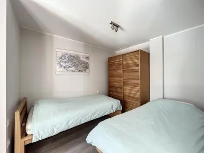 two beds in a small bedroom with white walls at Appartement rénové à Chamonix, balcon, parking - FR-1-507-37 in Chamonix-Mont-Blanc