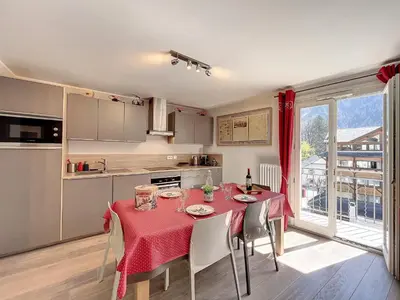 a kitchen with a table with a red table cloth at Appartement rénové à Chamonix, balcon, parking - FR-1-507-37 in Chamonix-Mont-Blanc