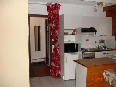 a kitchen with a red shower curtain in a kitchen at Appartement les Carroz d'Arraches in Les Carroz d'Araches