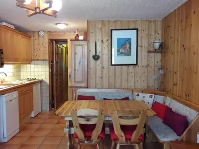 a kitchen with a wooden table and chairs in a room at Le Panda in Les Carroz d'Araches