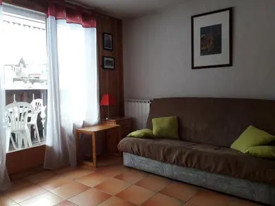 a living room with a couch and a window at Le Panda in Les Carroz d'Araches