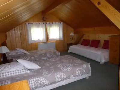 a attic bedroom with two beds and a couch at Chalet * Lioutraz * in Chamonix-Mont-Blanc