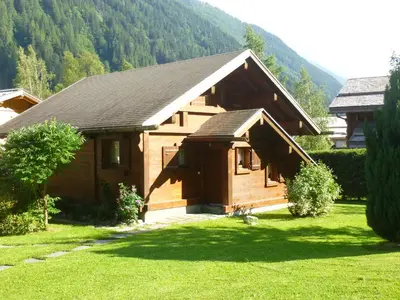 a wooden cabin in the middle of a grass field at Chalet * Lioutraz * in Chamonix-Mont-Blanc