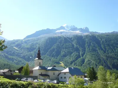 a church with a mountain in the background at Chalet * Lioutraz * in Chamonix-Mont-Blanc
