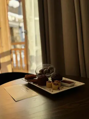 a tray of desserts on a table with a plate of food at Au Vieux Moulin in Megève