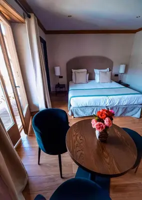 a bedroom with a bed and a table with flowers on it at Au Vieux Moulin in Megève