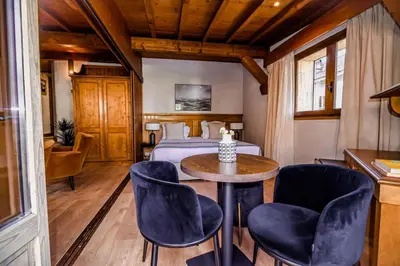 a bedroom with a bed and a table and chairs at Au Vieux Moulin in Megève