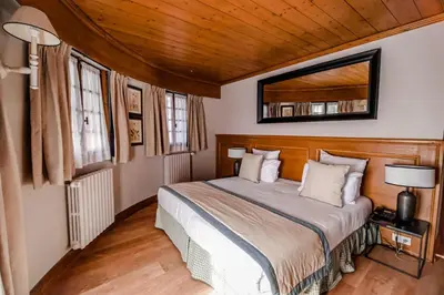 a bedroom with a bed and a mirror on the wall at Au Vieux Moulin in Megève