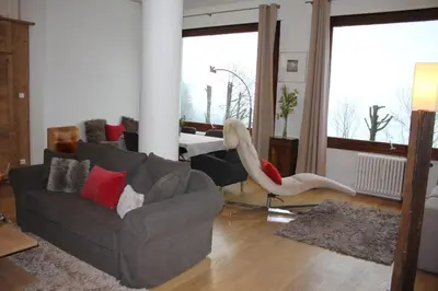 a living room with a couch and a large window at Les Campanules in Les Houches