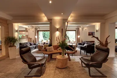 a large living room with chairs and a table at Les Campanules in Les Houches
