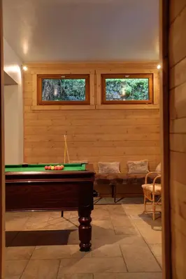 a room with a pool table and two windows at Les Campanules in Les Houches