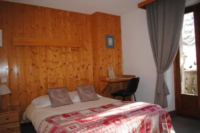 a bedroom with a bed with a wooden wall at Hotel Val Joly in Saint-Gervais-les-Bains