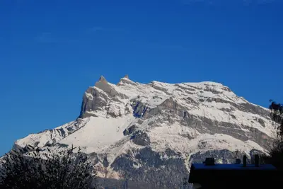 a snow covered mountain with a blue sky at Hotel Val Joly in Saint-Gervais-les-Bains
